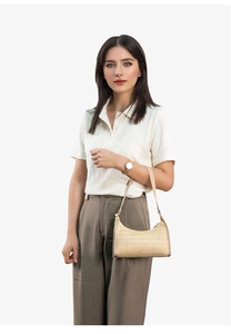 Detail of a beige woven crescent shoulder bag showing fine texture and summer holiday style