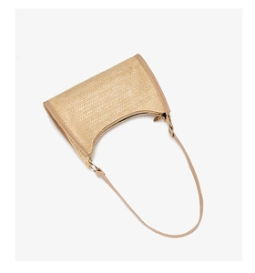 Detail of the woven straw texture and premium PU leather strap on this beige hobo bag