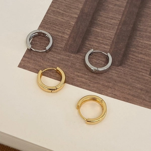 Minimalist 18k gold and silver plated hoop earrings on a rustic aesthetic background