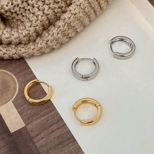 Close-up of classic gold and silver metal hoop earrings with polished mirror finish