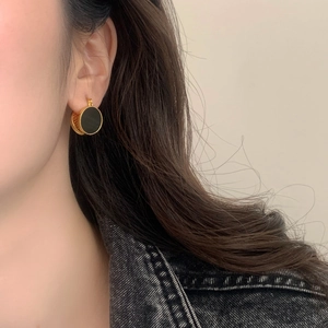 French vintage round gold-plated hoop earrings with black stone inlay on female model
