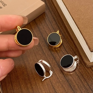 Detail of vintage French round hoop earrings with black enamel and milgrain edge texture
