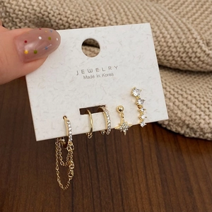 Detailed view of 5-piece gold earring set with star charms and zircons on jewelry card