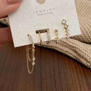 Detail of 5-piece gold moon and star earring set with white zircons on a card