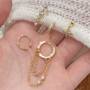 Elegant gold star and moon stud earring set with zircons shown on soft white fabric