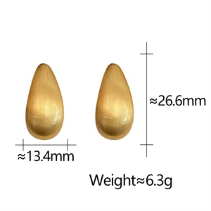 Détail de boucles d'oreilles goutte dorées, texture brossée, 26,6 mm de haut, 13,4 mm de large