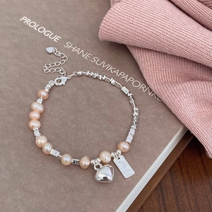 Details des Perlenarmbands mit Herzanhänger und graviertem quadratischem Anhänger