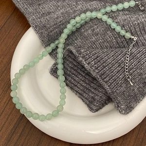 Close-up of light green natural stone beaded necklace with adjustable silver lobster clasp