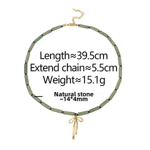 Detail of green natural stone cylinder beads with a golden metal bow pendant on a necklace