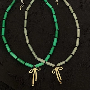 Bamboo-style natural stone necklace with a golden bow pendant in dark green and light gray