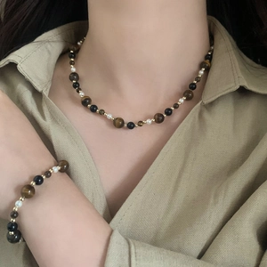 Close-up of tiger eye stone and freshwater pearl beaded necklace and bracelet set