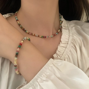 Colorful natural stone beaded necklace and bracelet set with golden metal accents