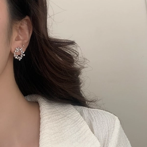 Close-up of elegant pearl wreath earrings with sparkling crystals on female model