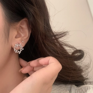 Close-up of French vintage pearl wreath earrings with sparkling crystals on ear