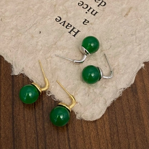 Macro detail of green chalcedony stud earrings in gold and silver finish