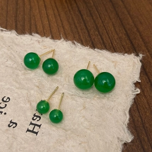 Three sizes of green chalcedony stud earrings with gold pins on textured beige paper
