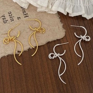 Elegant gold and silver metallic ribbon bow dangle earrings in a stylish tassel design