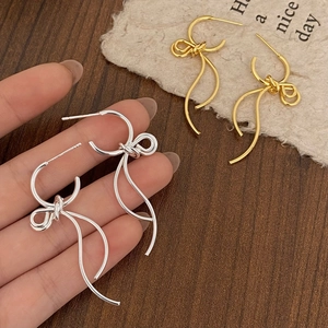 Minimalist metallic bow earrings with fluid fringe design in gold and silver finish
