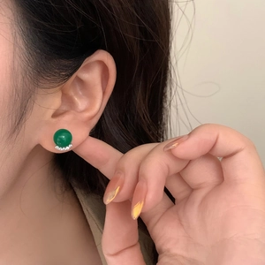 Elegant green chalcedony stud earrings with zircon accents on a model's ear