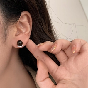 Close-up of black pearl stud earrings with sparkling micro-pave zirconia accents