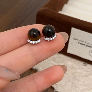 Macro detail of elegant stud earrings with brown gemstones and micro-pave cubic zirconia