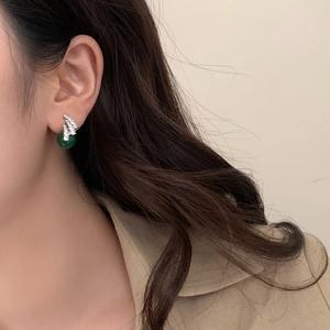 Close-up of vintage green chalcedony earrings with sparkling zircon inlay on the model