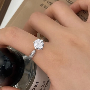 Close-up of a sparkling round-cut solitaire zircon ring with micro-pave diamond band
