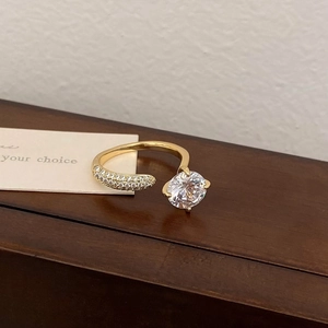 Detail of gold zircon ring featuring a large round stone and pavé crystal accents