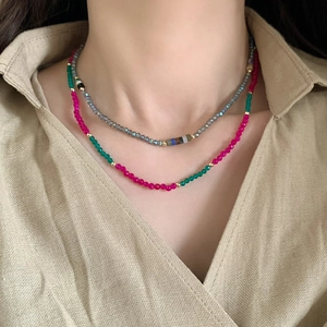 Double-layered natural stone necklace with colorful beads and gold accents on a model
