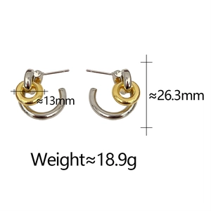 Détail de boucles d'oreilles créoles bicolores entrelacées en métal doré et argenté
