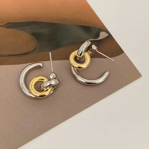 Detail of two-tone linked circular earrings with gold and silver metallic finish