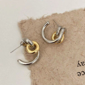 Macro detail of French design interlocking gold and silver geometric hoop earrings