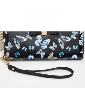Détails du portefeuille avec imprimé papillon, fermoir doré et dragonne amovible