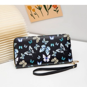 Détail du portefeuille en cuir noir avec imprimé papillon bleu et fermeture éclair dorée