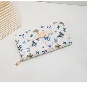 Détail du portefeuille long à motifs papillons bleus avec un nœud décoratif en métal doré