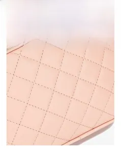 Detail of pink quilted leather camera bag featuring precise stitching and metal zipper