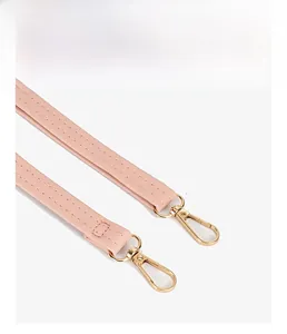 Detailed view of pink leather strap featuring double stitching and a golden metal clasp