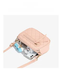 Pink quilted crossbody bag showing internal capacity with phone and cosmetics