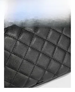 Detailed macro view of the black quilted leather texture and neat stitching on a square bag