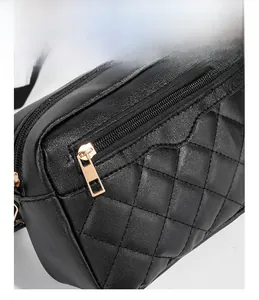 Detail of black quilted shoulder bag featuring gold hardware and smooth metal zipper