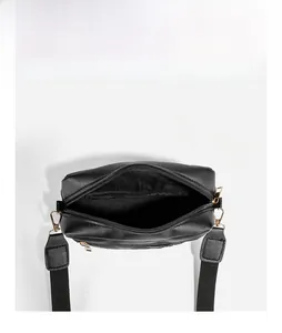 Top view of black quilted crossbody bag with golden zipper and spacious inner compartment