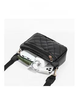 Detail view showing internal capacity of black quilted shoulder bag with essentials