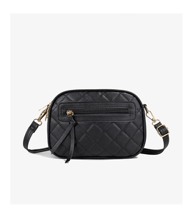 Macro detail of black quilted camera bag with golden hardware and triple zip pockets