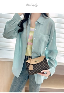 Chic monogram crossbody bag with golden chain strap shown on model in soft lighting