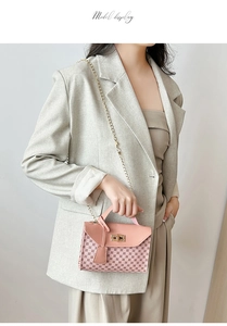 Model wearing a pink chain handbag with geometric print and gold twist-lock closure