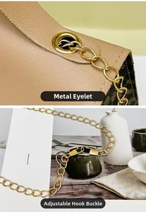 Close-up of golden metal chain hook and adjustable buckle on tan leather handbag