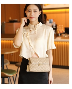Detailansicht der beige gesteppten Schultertasche mit Goldkette und Seidenquaste