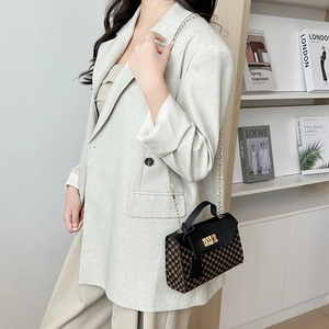 Chic 2024 textured crossbody bag with gold hardware and chain strap on a model