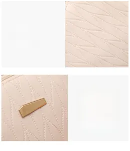 Detail of leaf pattern stitching and gold-tone geometric hardware on beige handbag