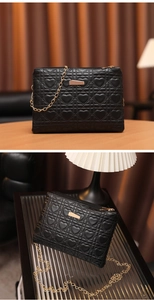 Close-up of heart-quilted black leather bag with elegant gold chain and metal clasp